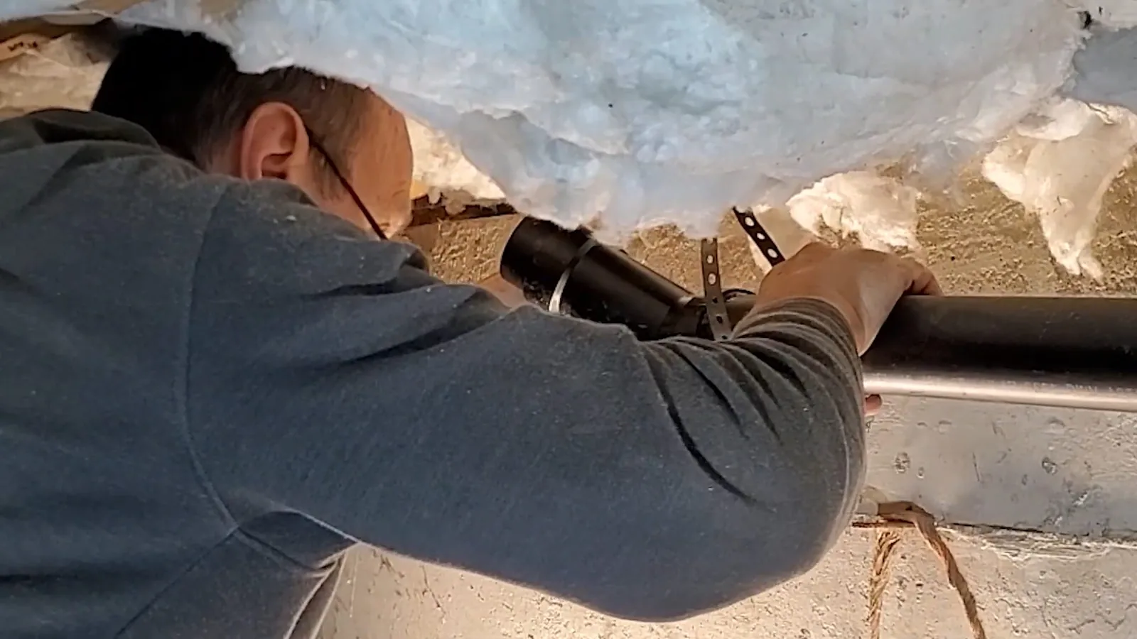 A drain line re-sloped and supported inside a crawl space, representing Crawl Space Plumbing service