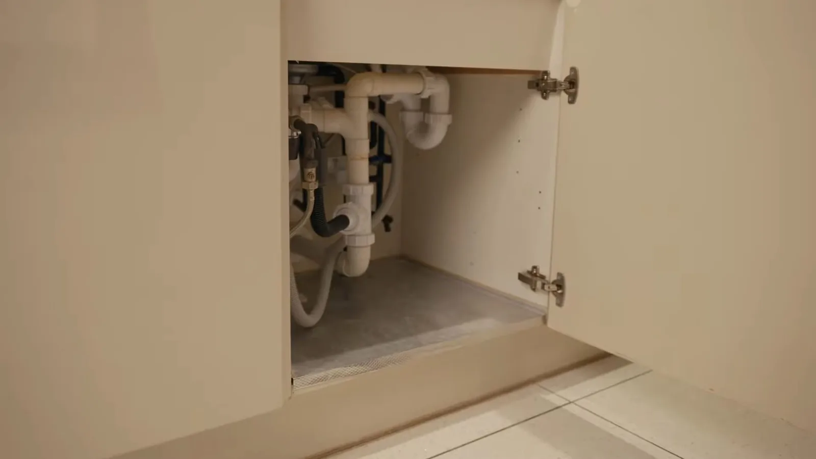 A sink supply line being reconnected under a cabinet during Faucet & Sink Repair service in Alpharetta
