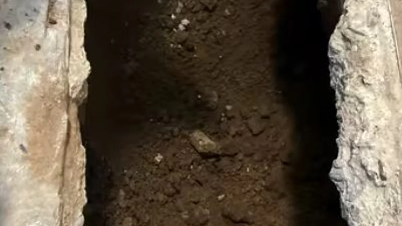 A section of concrete slab opened to reach a leaking pipe, representing Slab Leak Detection & Repair service