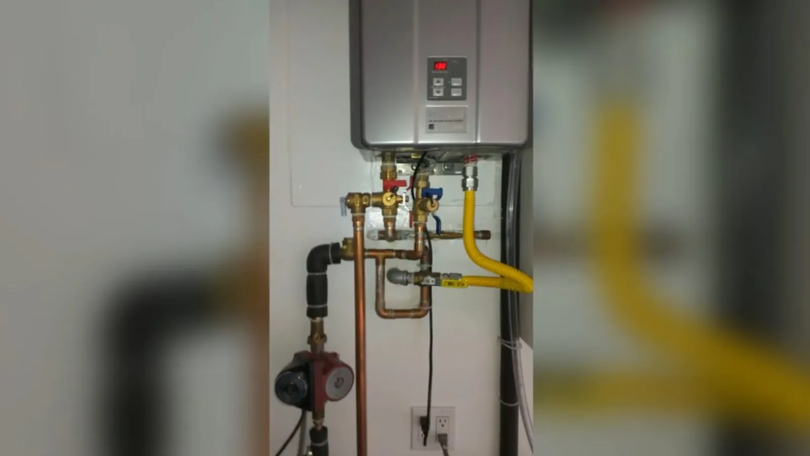 A technician inspecting a water heater's burner assembly, related to Water Heater Repair questions homeowners ask